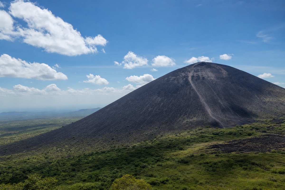 A rider sliding down the black ash slope of Cerro Negro volcano near Leon, Nicaragua