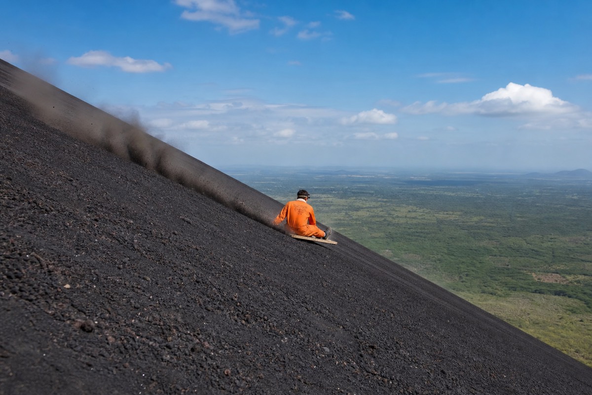 Volcano boarding down the black ash slope of Cerro Negro